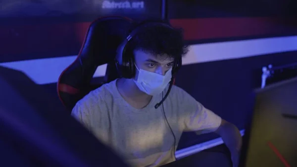 Close up de Jovem Gamer na máscara facial joga em jogo de vídeo on-line no clube de computador moderno . — Fotografia de Stock