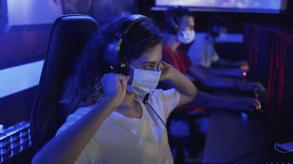 Femme ennuyeuse masques joue dans les jeux vidéo dans le club informatique moderne. — Photo