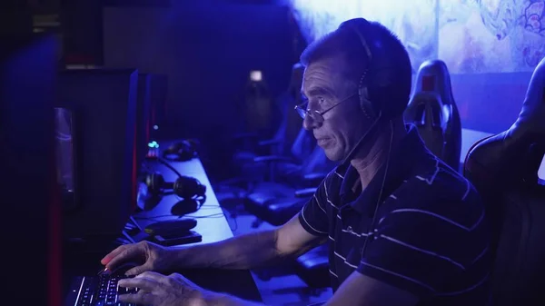 Velho homem gamer está emocionalmente jogando e perdendo em um jogo de computador — Fotografia de Stock