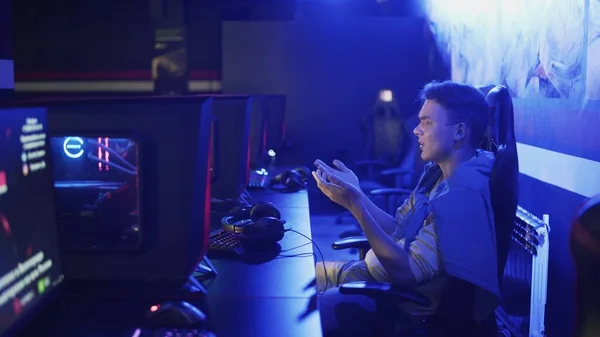 Концентрированный человек, играющий в онлайн видеоигру в современном киберспортивном клубе — стоковое фото