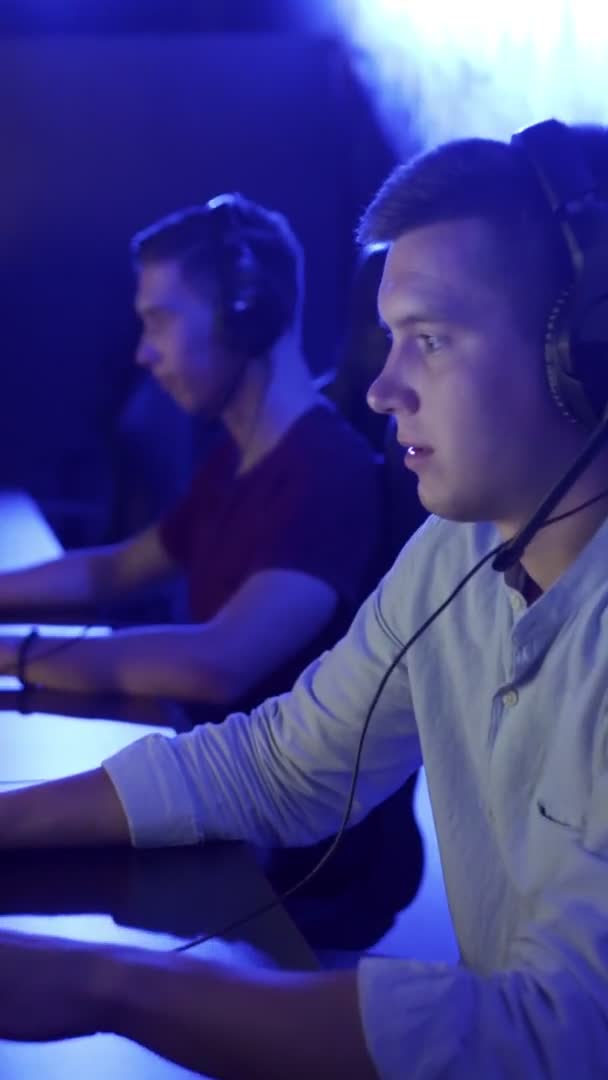 Deux jeunes joueurs masculins dans des casques jouant et perdant dans le jeu vidéo en ligne eSport Cyber Games Concept. VIDEO VERTICALE — Video