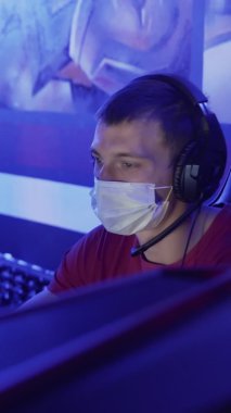 Modern bilgisayar kulübündeki Video Oyunları 'nda maskeli genç oyuncuların yakın çekimleri. VERTICAL VIDEO