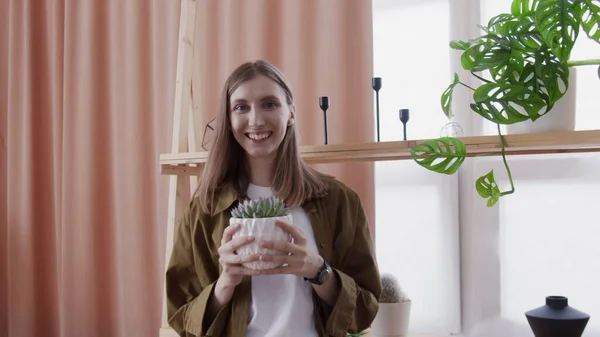 Junge Lifestyle-Bloggerin blickt in die Kamera und macht Video zu ihren Hausblumen — Stockfoto