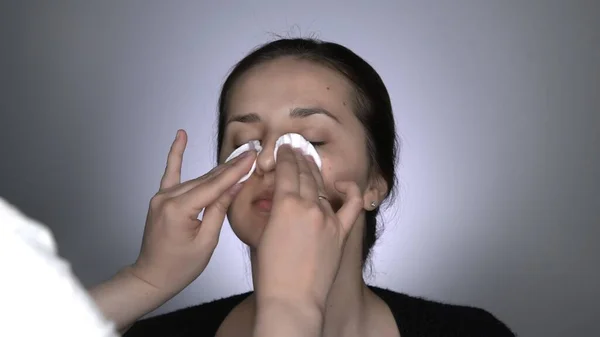 Retrato de estudio de mujer joven, hermosa y natural que aplica crema para el cuidado de la piel antes del maquillaje — Foto de Stock