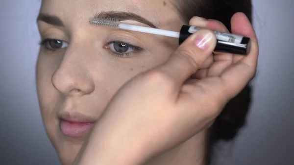 Prozess der professionellen Make-up für schöne und wunderschöne Frau sitzt im Studio. Make-up Artist Make-up Augenbrauen mit Pinsel — Stockfoto