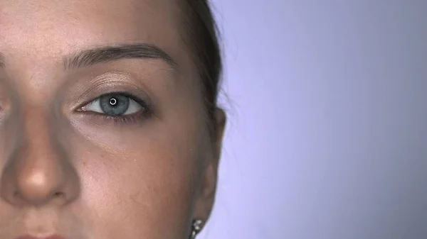 Μακρο πλάνο του Μακιγιάζ καλλιτέχνη κάνοντας επαγγελματική make-up για τη νεαρή γυναίκα στο στούντιο ομορφιάς. Μακιγιάζ Καλλιτέχνης χρησιμοποιεί το δάχτυλο για να εφαρμόσει glitter στα μάτια — Φωτογραφία Αρχείου
