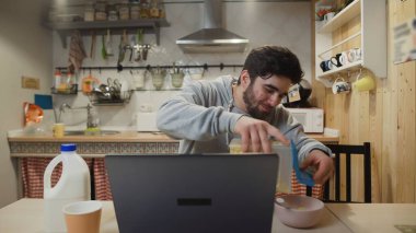 İşadamı dizüstü bilgisayarda çalışıyor ve mısır gevreği yiyor..