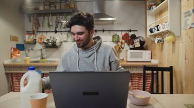 İşadamı dizüstü bilgisayarda çalışıyor ve mısır gevreği yiyor..