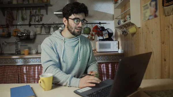 Elinde kredi kartı olan genç bir adam çevrimiçi alışveriş yapmak üzere.