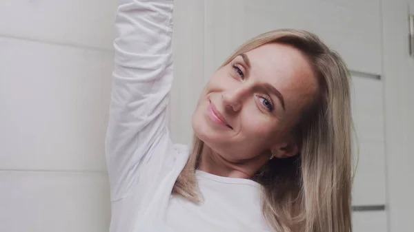 Close-up van elegant jong vrouw kijken naar de camera in badkamer — Stockfoto