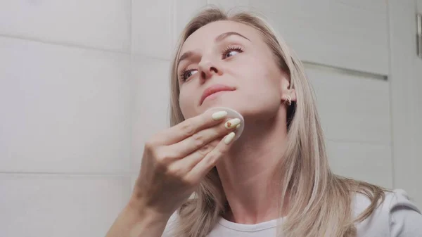 Mujer aplicación de loción y mirando en el espejo disfrutar de la belleza natural y saludable — Foto de Stock