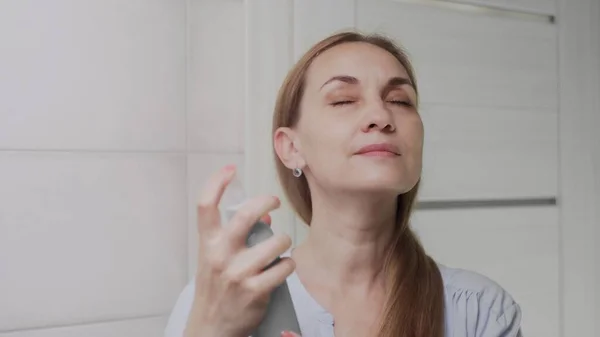 Close up Adult woman applying water spray for skin hydration — Stock Photo, Image