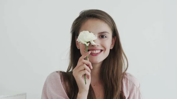 Modelo jovem bonita atraente com flores olhando e posando para a câmera — Fotografia de Stock