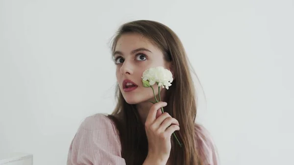 Modelo jovem bonita atraente com flores olhando e posando para a câmera — Fotografia de Stock
