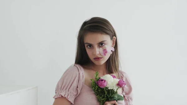 Επαγγελματική νεαρή γυναίκα μοντέλο με λουλούδια αναζητούν και ποζάρουν στην κάμερα — Φωτογραφία Αρχείου