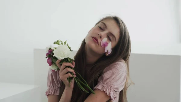 Szakmai fiatal nő modell virágokkal keres és pózol a kamera — Stock Fotó