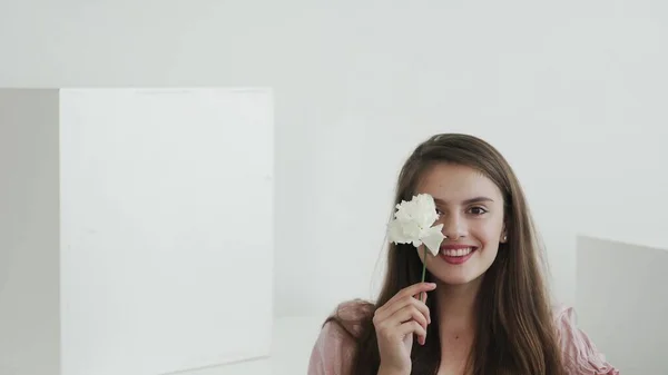 Modelo jovem bonita atraente com flores olhando e posando para a câmera — Fotografia de Stock