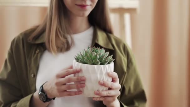 Jeune jardinière sourit et pose à la caméra avec son cactus dans les mains. — Video