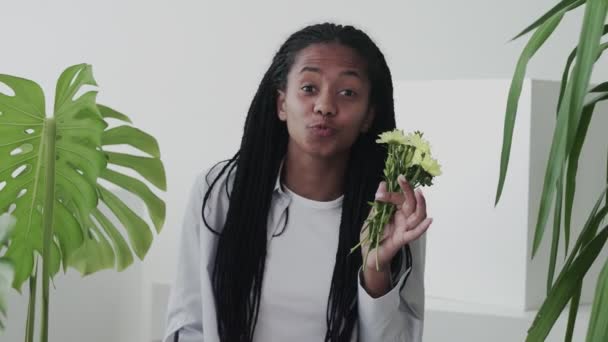 Atraktivní krásná africká americká žena model s květinami pohledu a pózování na kameru — Stock video