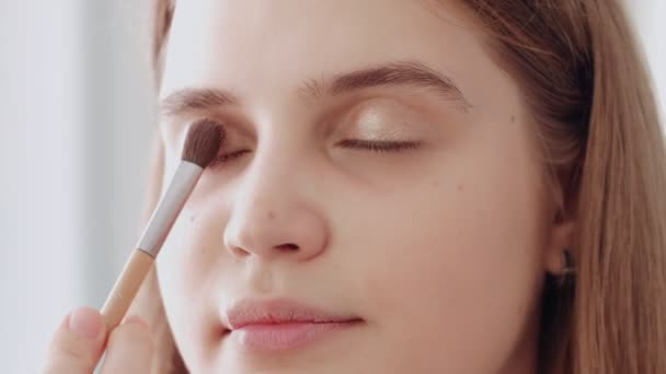 Make-up καλλιτέχνης βάζει σκιά χρώμα ματιών σε ένα όμορφο μοντέλο. Μακιγιάζ έργο καλλιτέχνη σε ένα σαλόνι ομορφιάς — Αρχείο Βίντεο