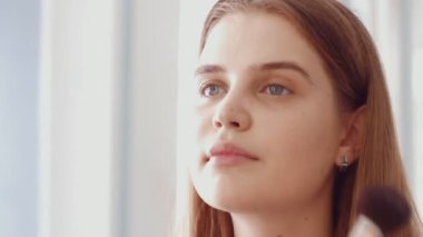 Profesyonel makyaj sanatçısı makyaj fırçası kullanarak modellerin yüzünü kızartıyor..