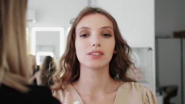 Profesyonel makyaj sanatçısı makyaj fırçası kullanarak modellerin yüzünü kızartıyor..