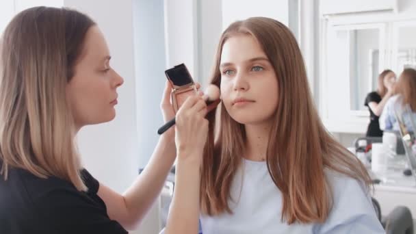 Επαγγελματική make up καλλιτέχνης χρησιμοποιεί μεγάλο πινέλο για να aplllies τόνο ή σκόνη — Αρχείο Βίντεο