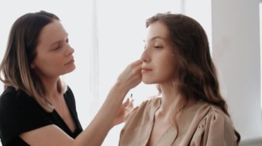 Makyöz, modellerin kaşlarını özel bir fırçayla tarar.