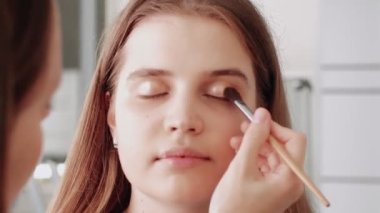 Profesyonel makyaj sanatçısı makyaj fırçası kullanarak modellerin yüzünü kızartıyor..