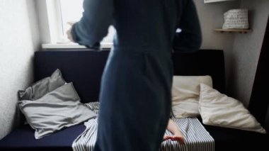 Küçük çocuk kanepede oturup waffle yer ve meyve suyu içerken annesi tabakta waffle fotoğrafı çeker.