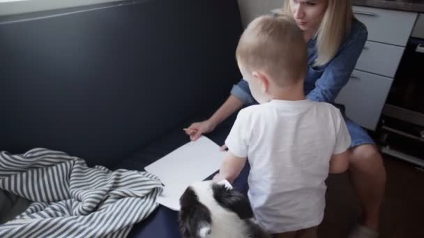 Mladá matka a její syn malují doma na gauči — Stock video