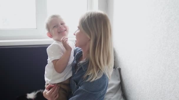Mladá matka a její syn se baví doma na gauči — Stock video
