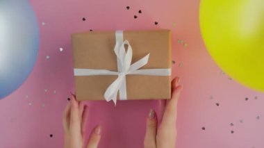 Noel hediyesi kutusu pembe arka plan görünümlü kadınların ellerinde.