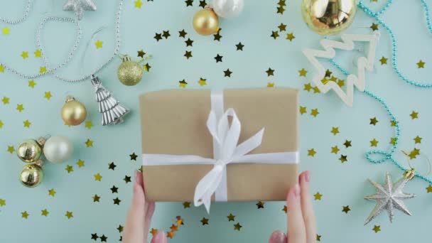 Vánoční dárková krabice v ženských rukou na modrém pozadí horní pohled — Stock video