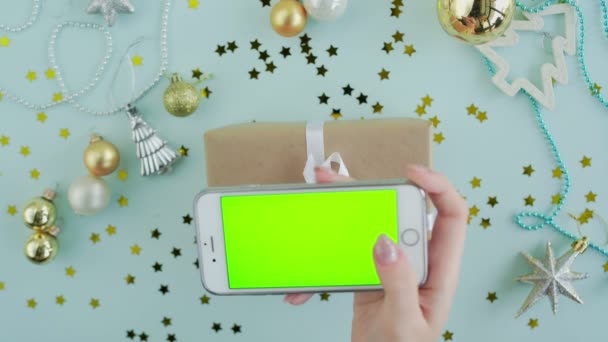 Felső nézet a nő használja telefon zöld képernyő ajándék doboz kék háttér — Stock videók