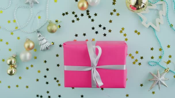 Woman takes christmas gift box in woman hands on blue background top view — Stock Video