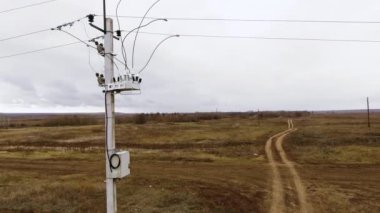 Yüksek voltajlı elektrik akımı. Yüksek gerilim kablolarını bulutların hareketinin arka planına yasla. Elektrik kablolarını belirli bir seviyede tutmak, bağlamak ve askıya almak için yapı.