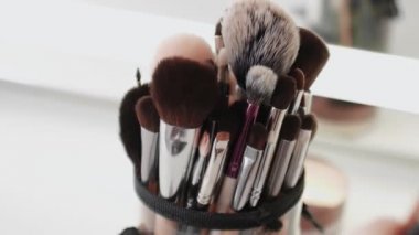 Masanın üzerinde bir sürü farklı makyaj fırçası var.