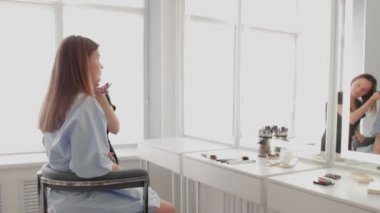 Yetişkin makyaj sanatçısı işini bitirip, makyajının keyfini çıkarırken oradan ayrıldı.