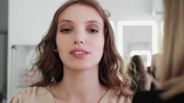 Profesyonel makyaj sanatçısı makyaj fırçası kullanarak modellerin yüzünü kızartıyor..