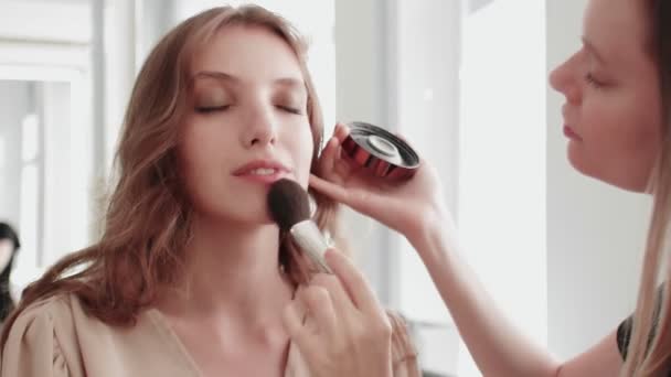 Profissional make up artista faz blush no rosto modelos usando pincel de maquiagem. — Vídeo de Stock