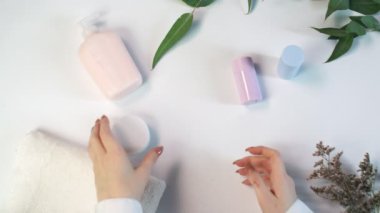 Kadın şişeyi kremayla açıyor. Güzellik teması düz. Profosyonel çevre ile yaratıcı planlama yatıyordu..