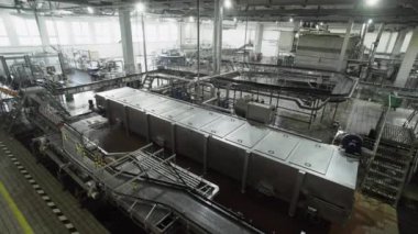 Bira fabrikasının içinde çalışan bir sürü makine var.