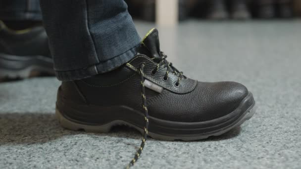 Вид сбоку, где человек кладет и завязывает ногу в работу или ботинки для похода, чтобы подготовиться к работе. — стоковое видео