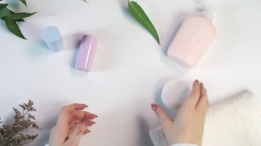 Kadın şişeyi kremayla açıyor. Güzellik teması düz. Profosyonel çevre ile yaratıcı planlama yatıyordu..