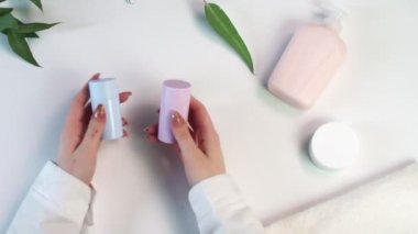 Kadının elinde iki tane mavi ve pembe deodorant var. Güzellik teması düz. Profosyonel çevre ile yaratıcı planlama yatıyordu..