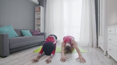 Komik eski tarz birkaç beyaz erkek ve afro kadın evde çocuk yoga pozu veriyorlar.