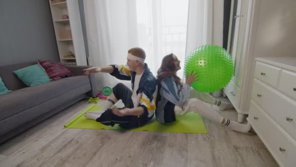 Young healthy couple man and woman are working at home. They doing exercise with fitness ball — Stock Video