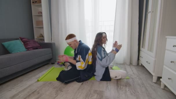 Pendatang baru pria dan wanita konyol dalam olahraga dengan pakaian olahraga berwarna-warni melakukan latihan tangan dengan band elastis — Stok Video
