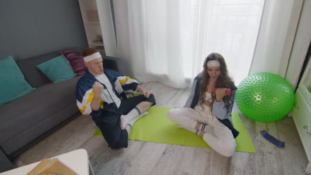 Pemuda bergaya Retro ingin makan pizza sementara pacarnya melakukan latihan dengan dumbbells — Stok Video